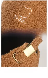 Close-up of brown sherpa baseball cap featuring teddy embroidery and metal adjustment buckle