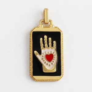 Detail of rectangular gold-plated Hamsa hand pendant with red heart and zircon inlay