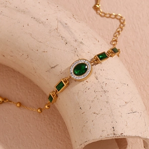 Macro shot of 18K gold plated bracelet with green oval stones and white zircon accents