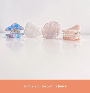 Detailed view of mini shell hair claws in colorful pearlescent acetate finishes