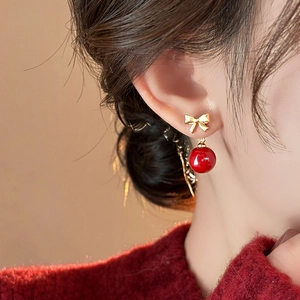 Elegant red round pendant earrings with golden bow knot shown on female model
