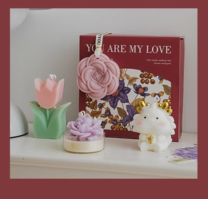 Detail of floral and dragon shaped candles in a gift box with you are my love text