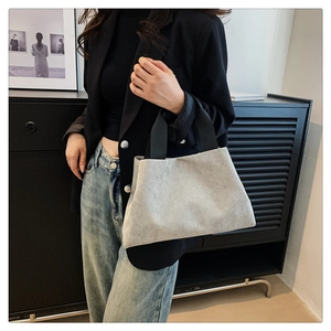 Détail du sac cabas en velours côtelé gris montrant la texture douce et les anses