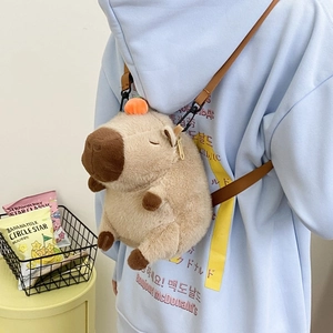 Close-up of brown plush capybara backpack with orange fruit ornament on model back