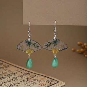 Detail of fan-shaped earring with bamboo pattern and emerald green teardrop bead