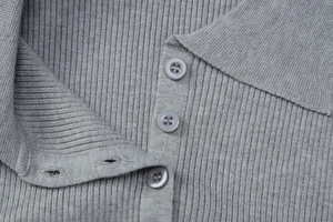 Detail of gray rib-knit polo collar and button placket on long sleeve dress