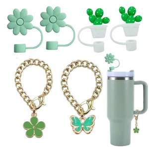 Detail of green butterfly and floral charms with silicone straw covers for tumblers