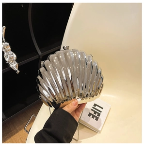 Detail shot of silver acrylic shell clutch bag with metallic glossy finish and beads