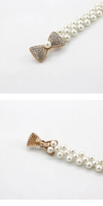 Détail d'une boucle nœud élégante avec strass et perles blanches sur ceinture élastique