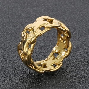 Macro detail of gold X-shaped hollow ring with chain texture and polished steel finish