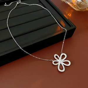 Détail du collier fleur évidée en argent avec pavé de zircons sur un plateau noir