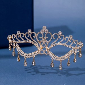 Dettaglio maschera dorata con strass e frange a goccia con motivi traforati di lusso