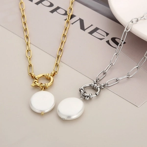 Close-up of gold and silver chunky link necklaces with white shell pearls and toggle clasps