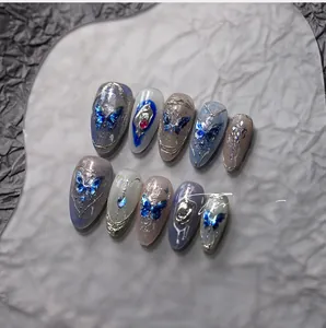 Détails macro de papillons holographiques bleus et pierres 3D sur ongles à presser