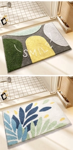Detail of absorbent plush bath mats with rainbow geometric smile and leaf patterns
