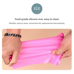 Detail shot of food-grade pink silicone baking mat being stretched showing high elasticity