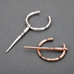 Detail of vintage Viking metal brooches in silver and bronze finishes with engravings