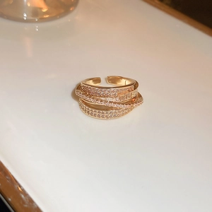 Close-up of layered 18K gold-plated ring with micro-paved zircons and baguette-cut stones