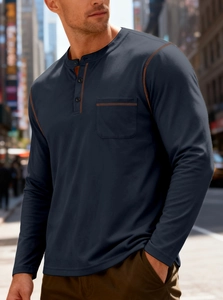 Detail of navy Henley shirt with orange contrast stitching and chest pocket on a male model