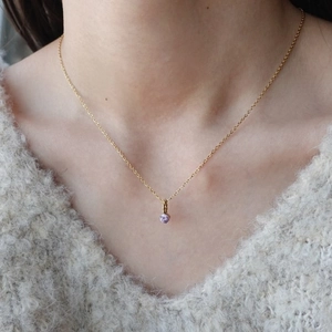 Collana minimalista in oro con ciondolo a pietra di nascita viola indossata da modella