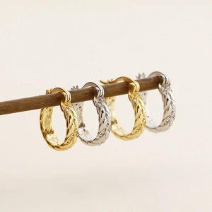 Detail of woven texture s925 silver wheat hoop earrings in gold and silver finishes