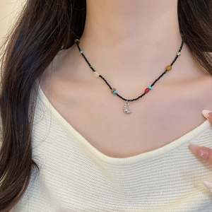Close-up of beaded necklace with colorful natural stones and silver moon pendant on neck