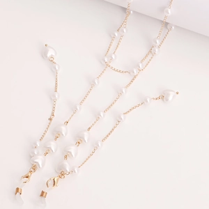 Detail of gold metal eyewear chain with white heart-shaped pearls and rubber loops