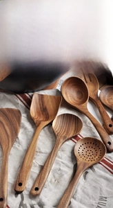 Detail view of premium acacia wood kitchen utensils including spatula and serving spoons