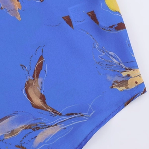 Dettaglio del tessuto in raso floreale con motivo astratto blu e giallo e cuciture