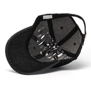 Detail view of cotton sweatband and adjustable metal buckle inside black denim baseball cap