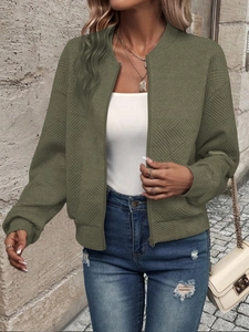 Close-up of diamond quilted texture and ribbed cuffs on an olive green bomber jacket