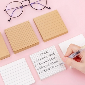 Detailopname van een hand die schrijft op gekleurde memoblaadjes en diverse notitieblokken
