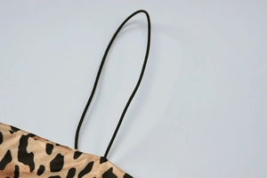 Detail of leopard print crop top featuring slim black elastic shoulder straps