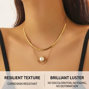 Detail of layered gold-plated stainless steel chain necklace with pearl fan pendant