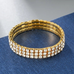 Close-up of three-row gold elastic bracelet featuring sparkling white rhinestones