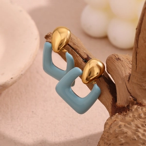 Detail of 18K gold-plated earrings with light blue enamel on a natural wood stand
