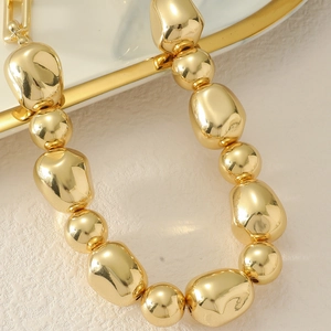 Chunky gold punk choker featuring high-polished irregular beads and spheres