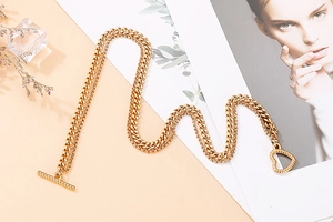 Detailed view of golden double-layer chain bracelet with heart-shaped ring and OT toggle clasp