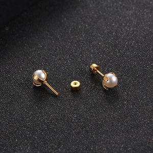 Elegant gold titanium steel stud earrings featuring round white pearls and screw backs