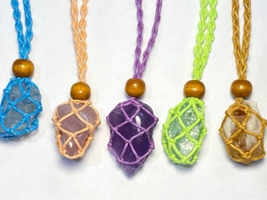 Detail view of colorful handmade woven pouches for crystal pendant necklaces