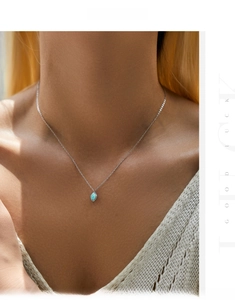 Close-up of s925 silver necklace featuring an oval blue opal on a wave-textured metal pendant