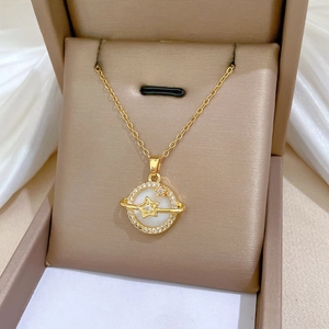 Macro shot of 18K gold plated shell planet necklace with cubic zirconia details
