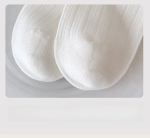 Detailed macro view of white cotton socks showing the seamless toe and knit texture