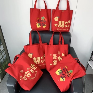 Detail of red wedding canvas tote bags with festive golden prints and metal snap buttons