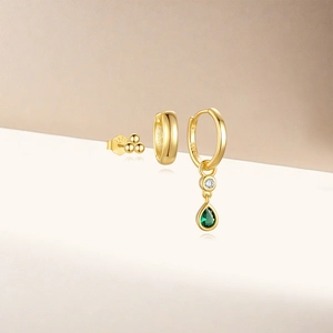 Detail of S925 sterling silver gold earrings with green teardrop stones and zircons
