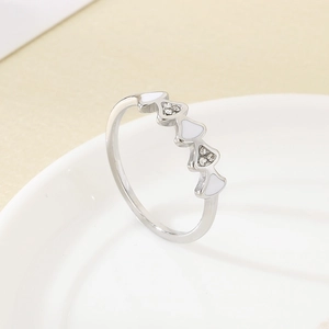 Détail macro d'une bague argentée avec cœurs en émail blanc et zircons cubiques