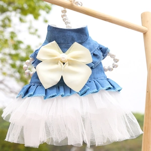Detail of pet denim dress with white layered tulle skirt and a large satin pearl bow