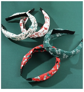 Detailed view of red, green, and white Christmas printed knotted fabric headbands