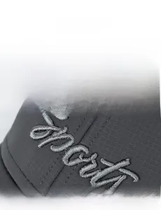 Detailed view of Sport 3D embroidery on dark grey textured baseball cap fabric