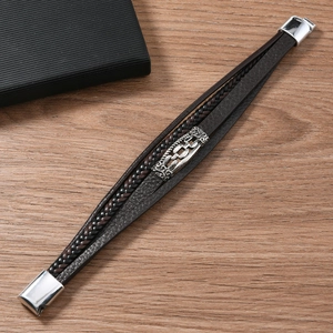 Detailed macro view of brown leather braided men's bracelet with silver magnetic clasp